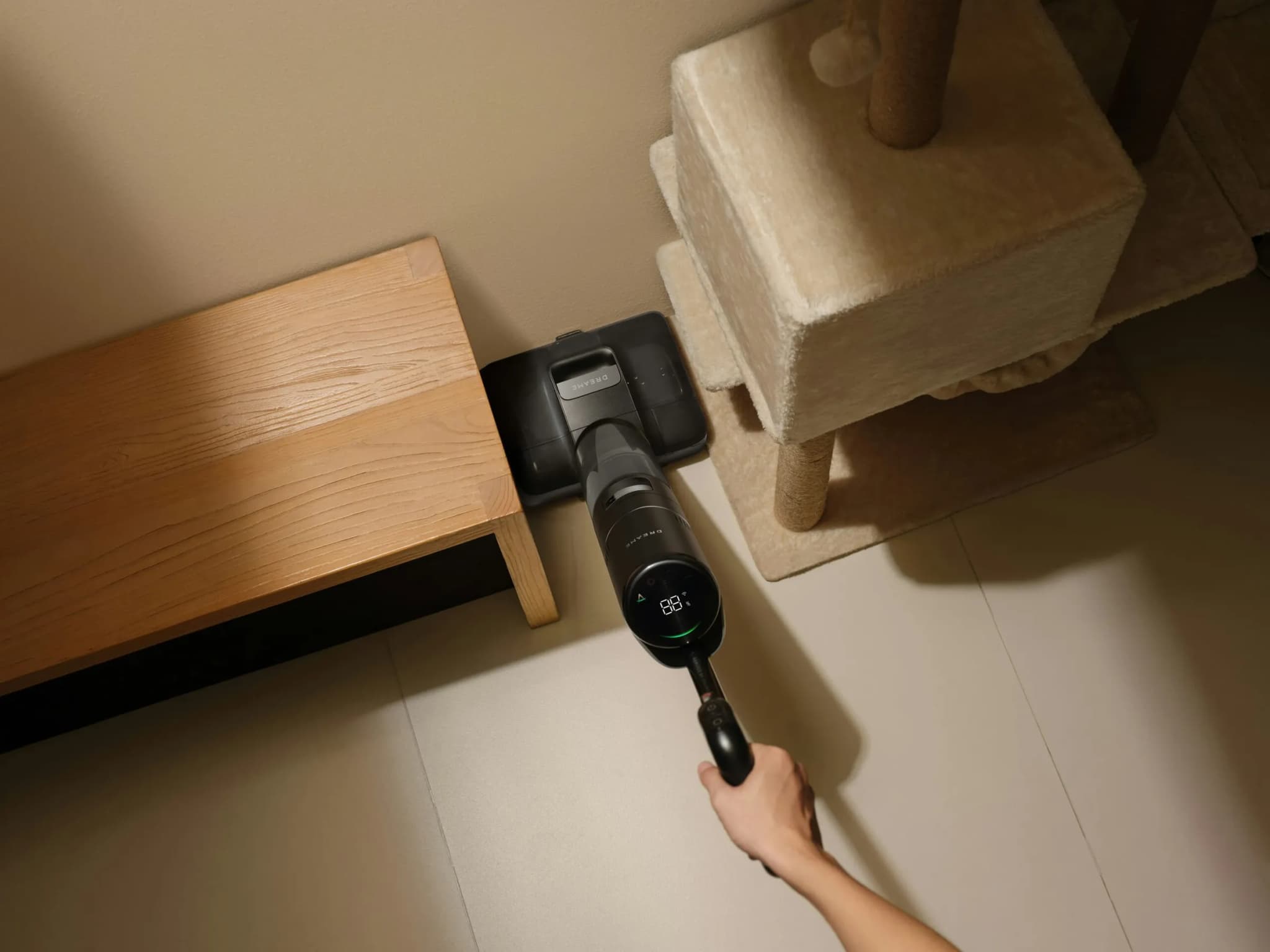Cordless floor cleaner on a light floor next to a low wooden table