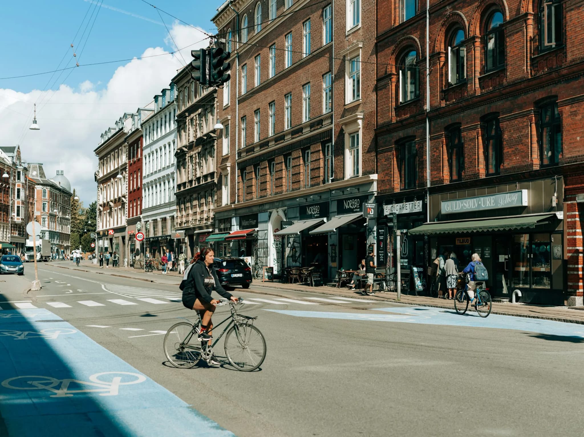 Gade med etageejendomme og cyklister i København