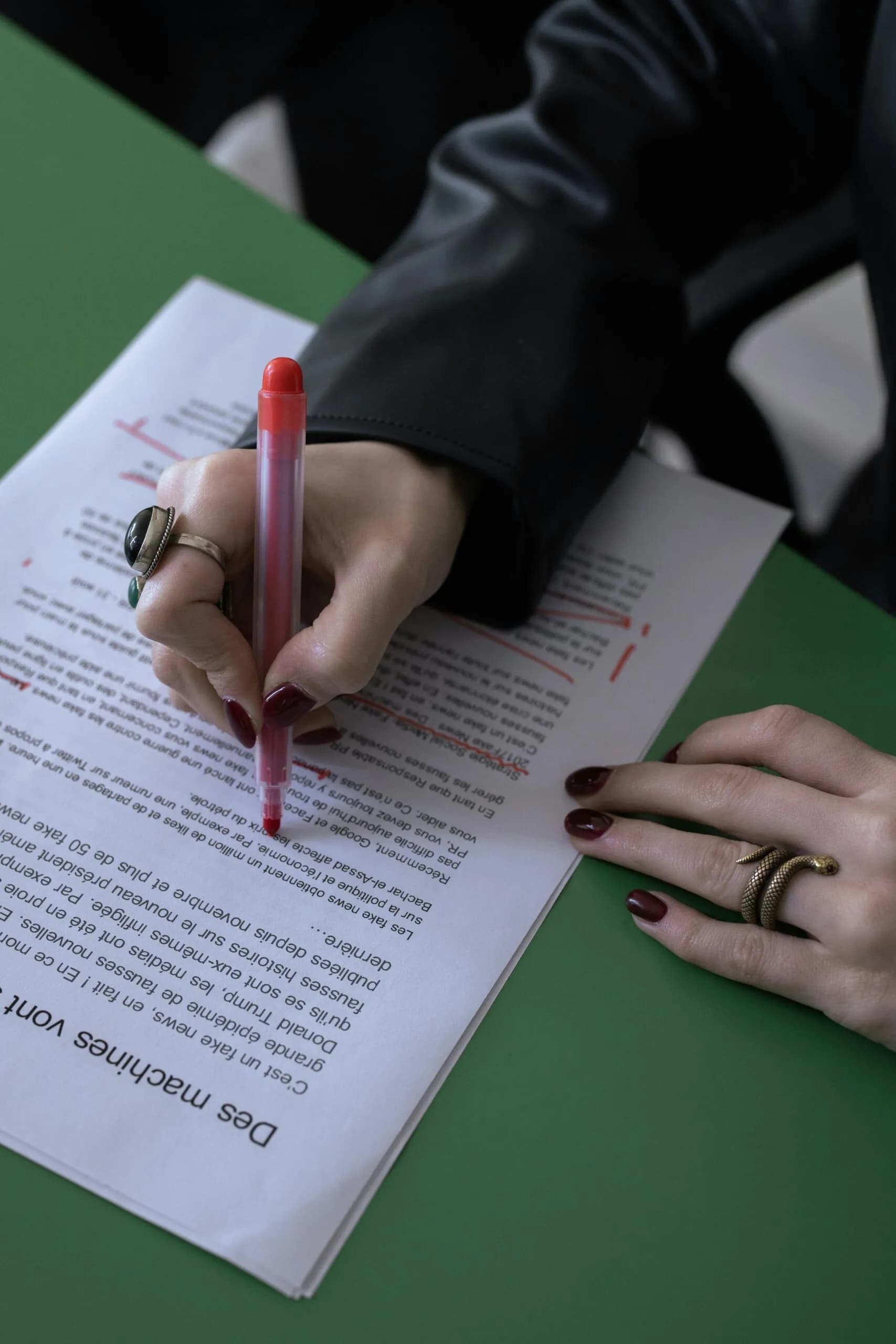 Hands reviewing a printed document with a red pen