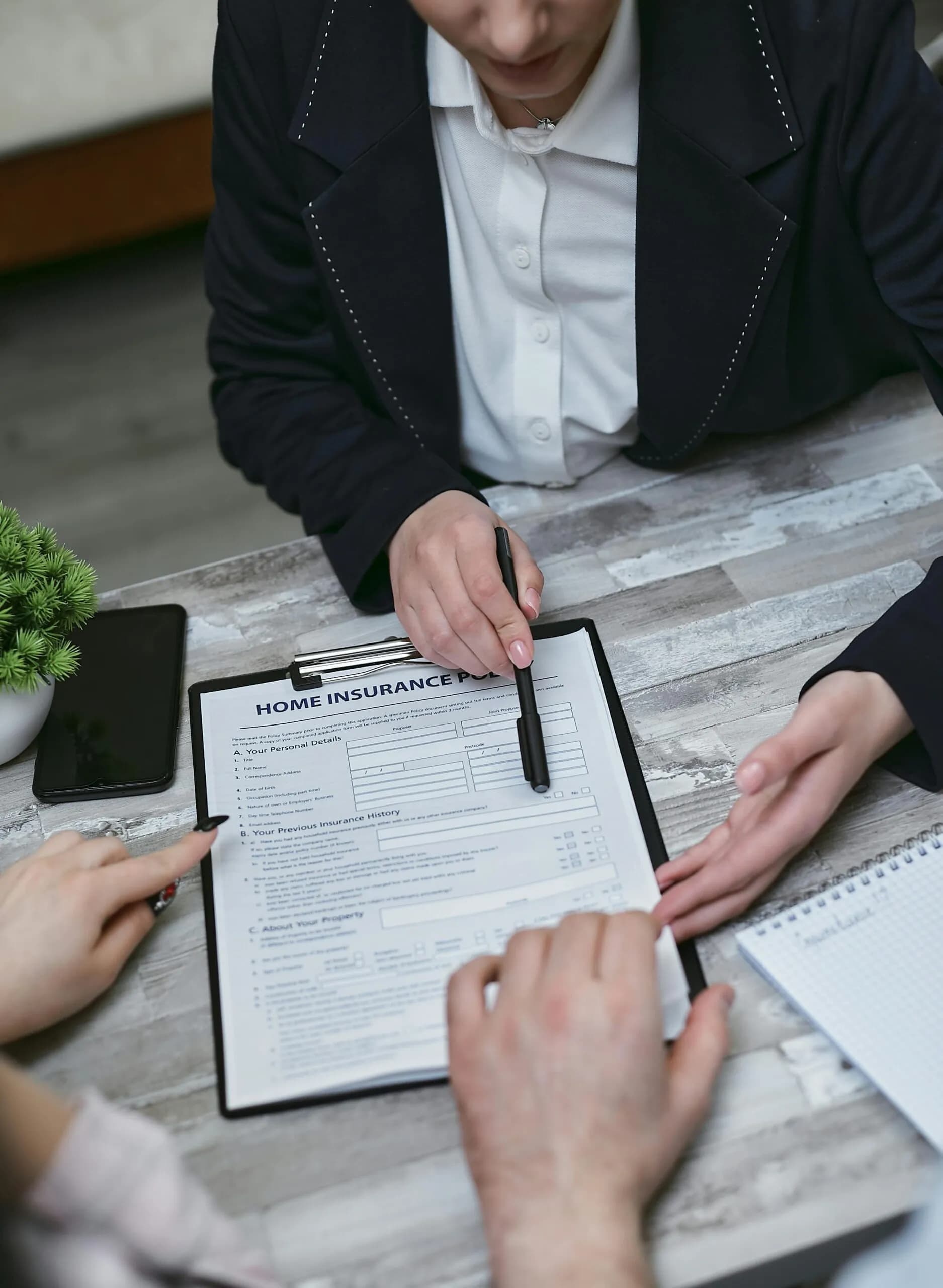 Two people go through a form on a clipboard at a table