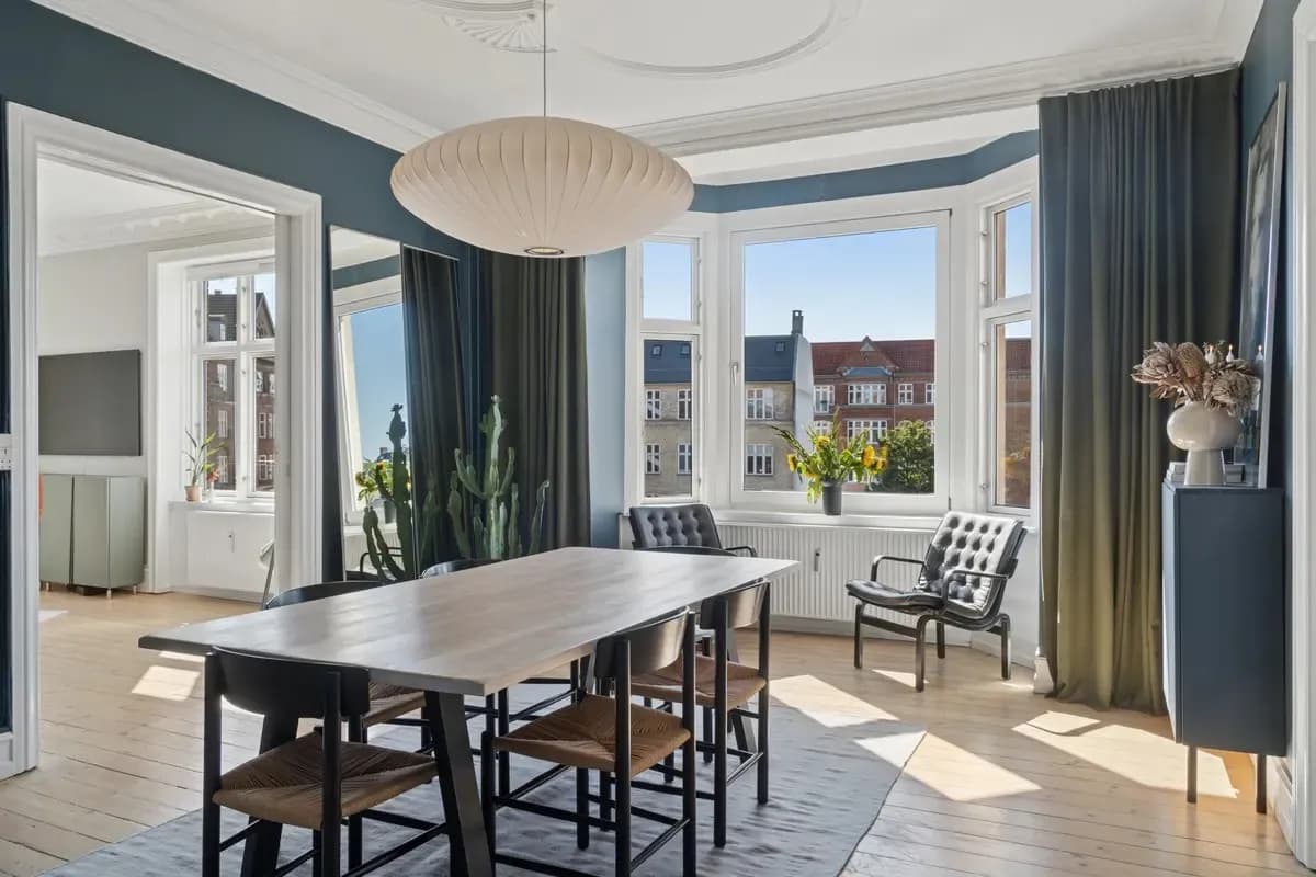 Bright dining room with a long wooden table and large windows