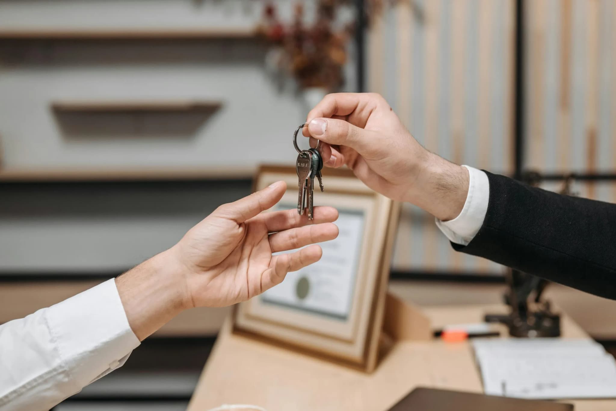 Hands exchanging keys in an office