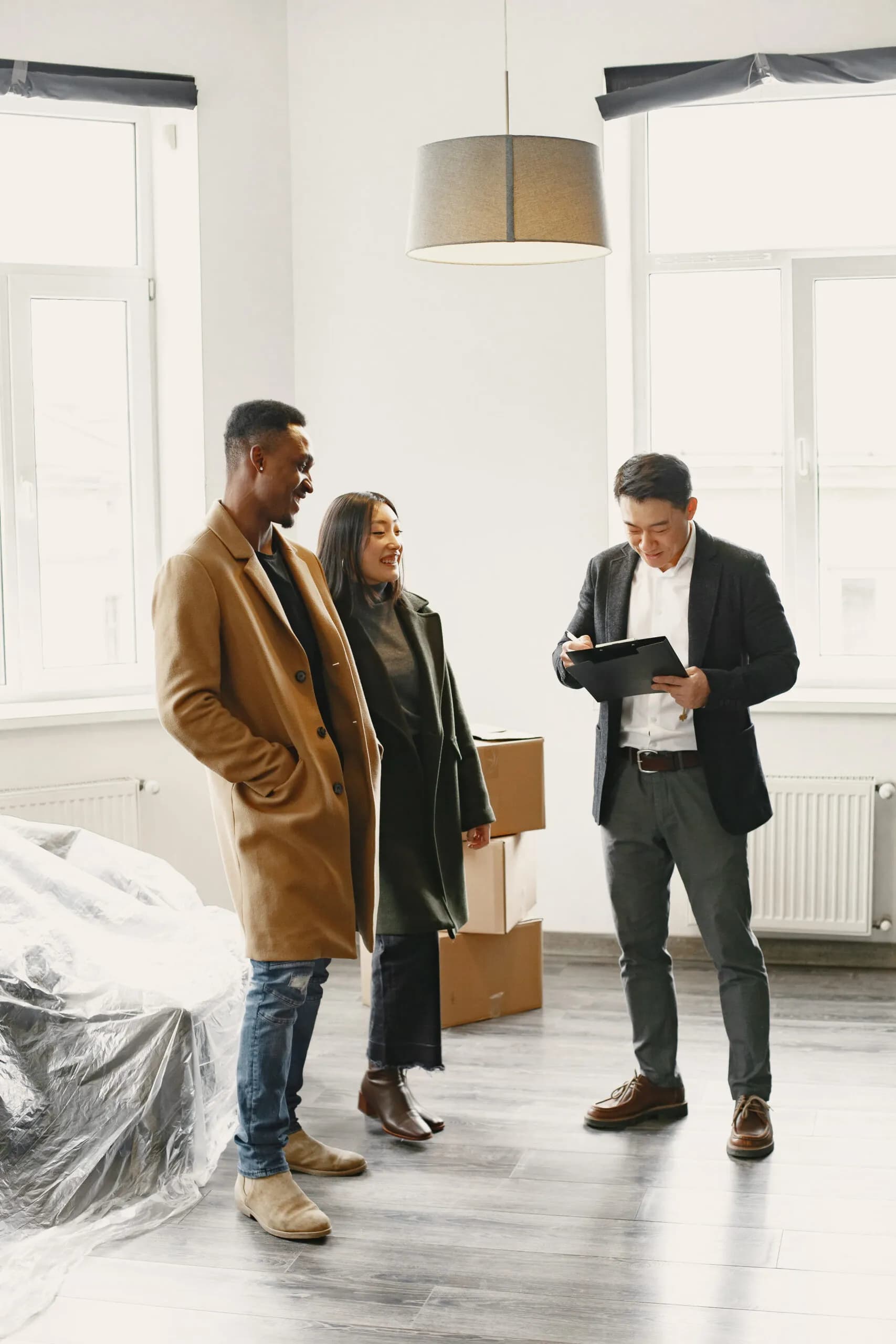 Three people in a bright, empty flat during a viewing