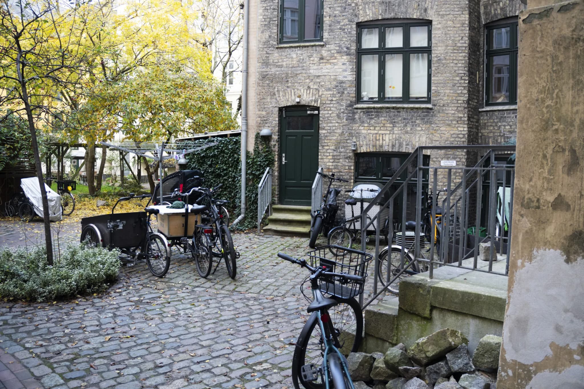Fælles gårdhave med cykler bag en etageejendom