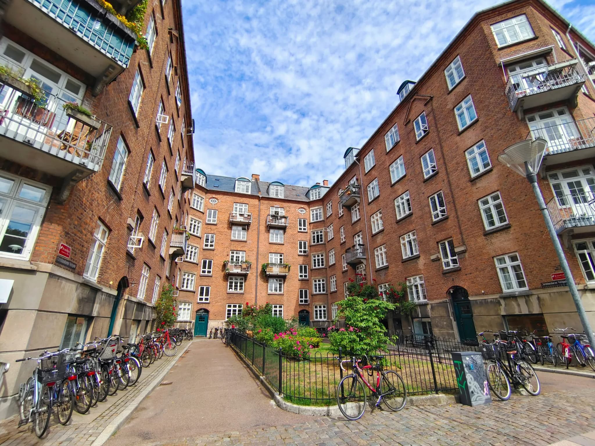 Courtyard between red-brick apartment buildings with balconies and bicycles