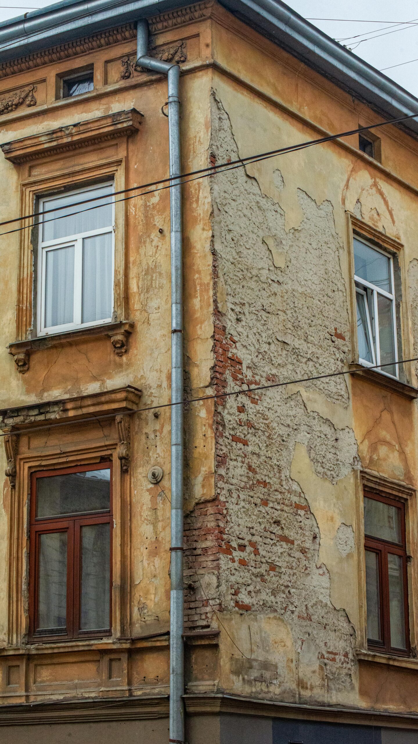 Detailed shot of an old urban building's corner with weathered textures and visible decay.